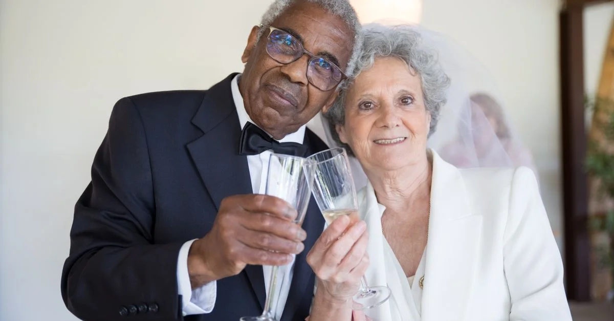 Un couple senior joyeux célébrant leur jour de mariage avec des toasts au champagne à l'intérieur, capturant l'essence de l'amour et de l'unité.