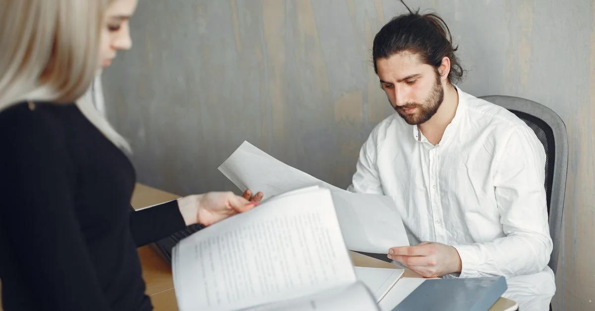 Deux professionnels examinant des documents importants dans un bureau moderne.