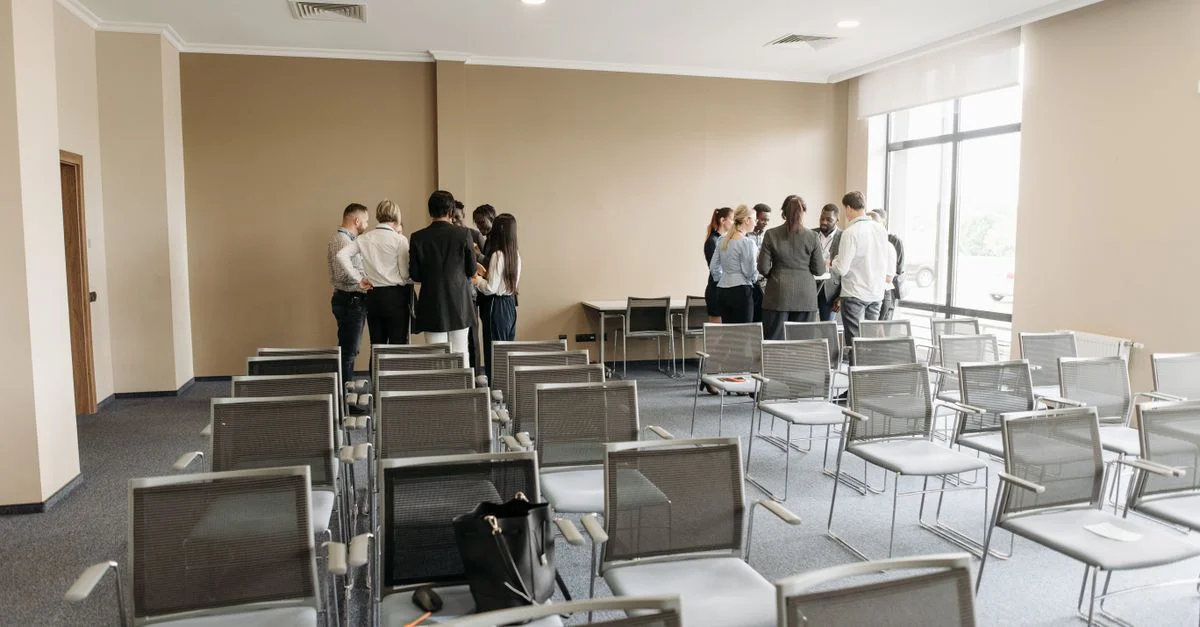 Un groupe diversifié de professionnels ayant une discussion dans une salle de conférence vide.
