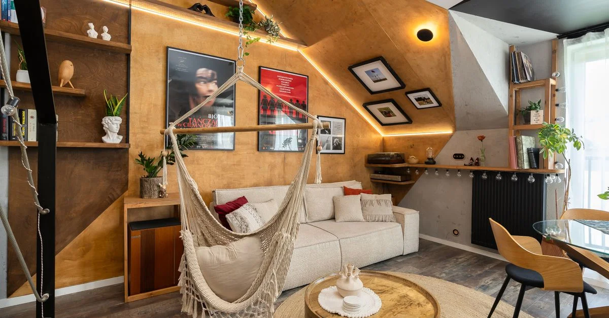 Salon élégant comprenant un hamac, des meubles en bois et des plantes d'intérieur, créant une atmosphère chaleureuse.